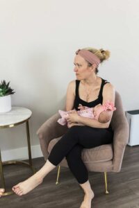 A mom sitting in a chair holding her newborn