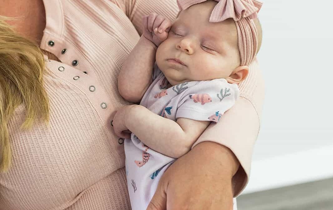 A newborn baby being held in its mothers arms