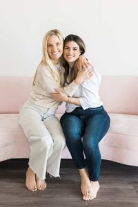 Two women hugging on a couch