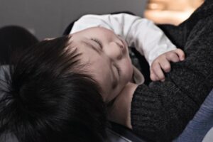 baby sleeping on mothers arm
