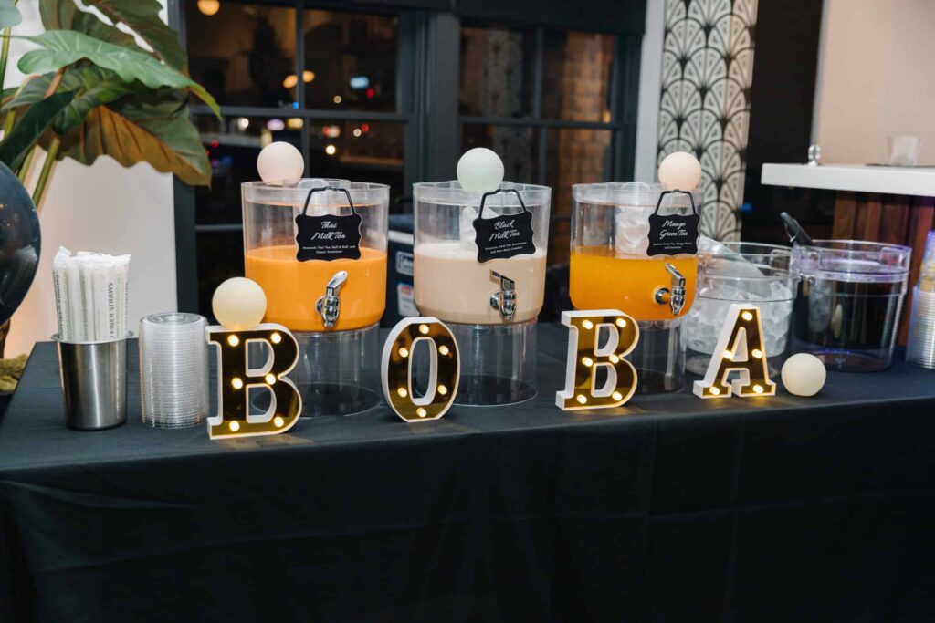 A table with three dispensers of Boba Tea