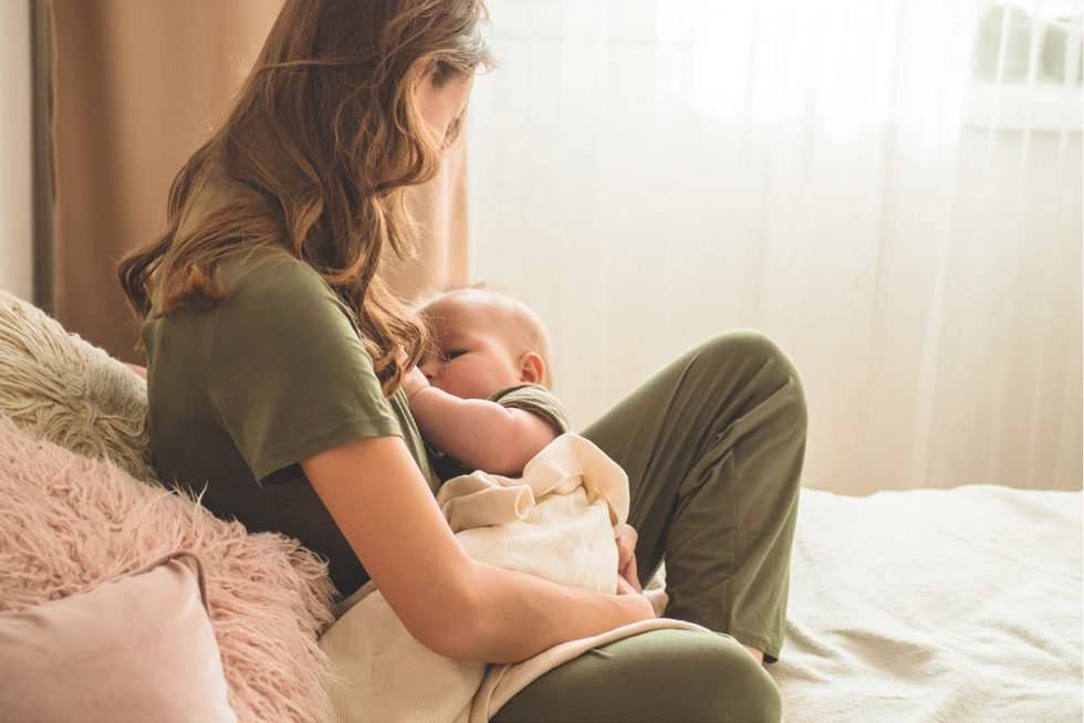 Mother nursing newborn with lactation consultant support in Rancho Cucamonga.
