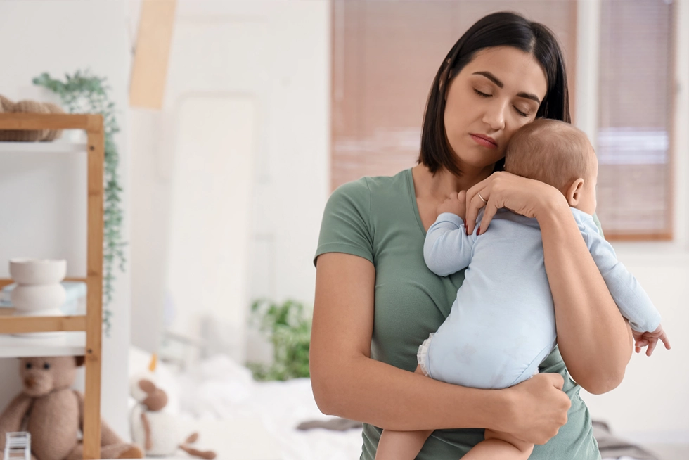 New mom holding her newborn baby at home in Greenville, SC.
