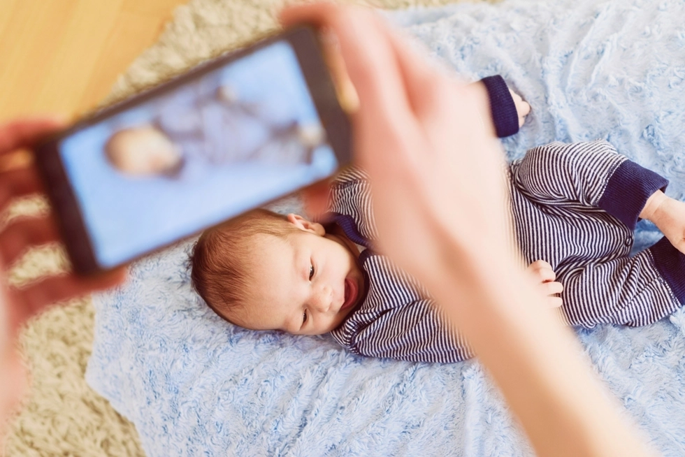 Parent taking a photo of a newborn baby during a lifestyle newborn photography session in Houston Greater Heights, Texas.