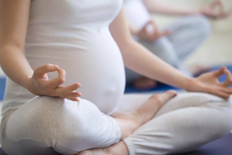 Pregnant woman practicing prenatal yoga and meditation during a wellness class in Philadelphia Rittenhouse, Pennsylvania.