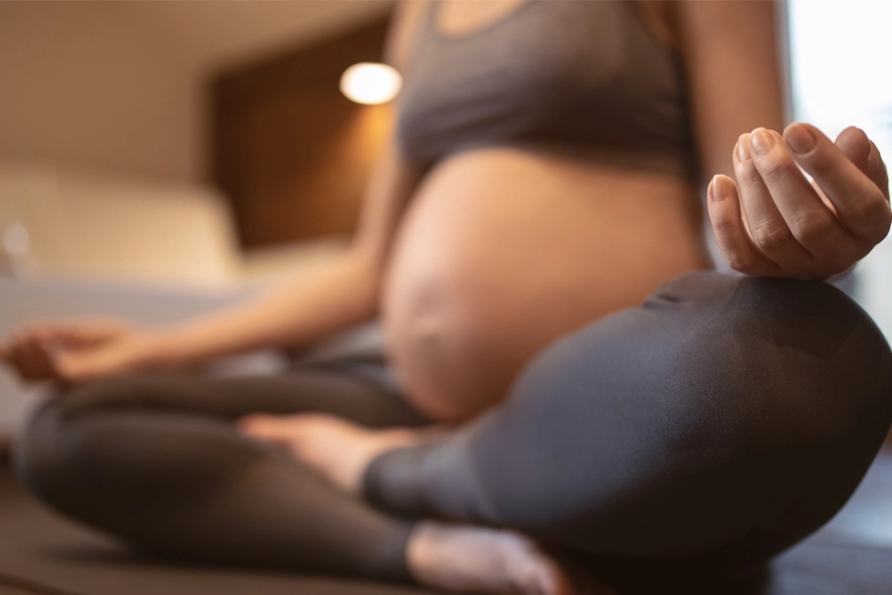 Pregnant woman practicing prenatal yoga and meditation during a wellness class in Rancho Cucamonga, California.